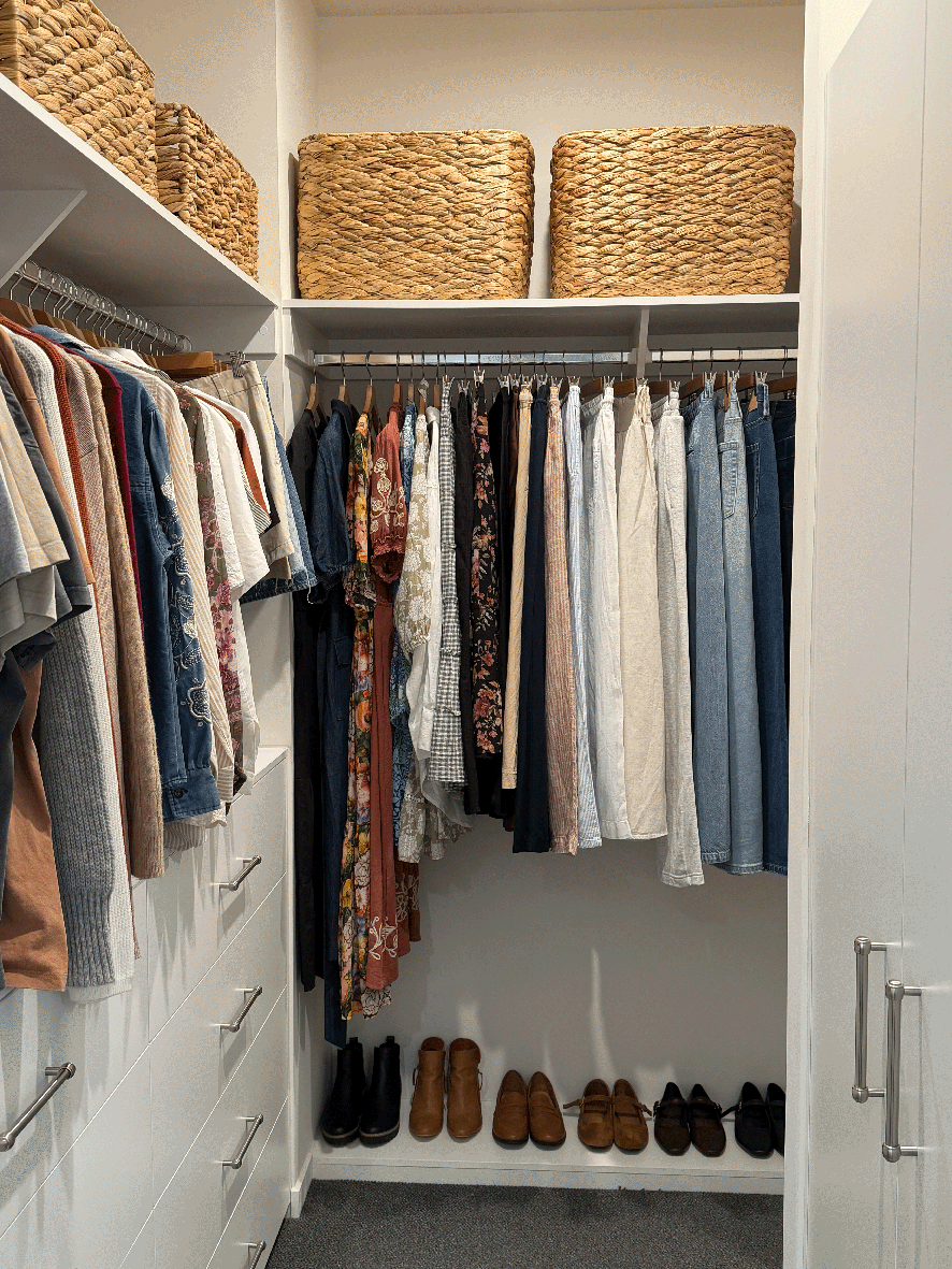 Wardrobe organised with hanging clothes, baskets and shoes